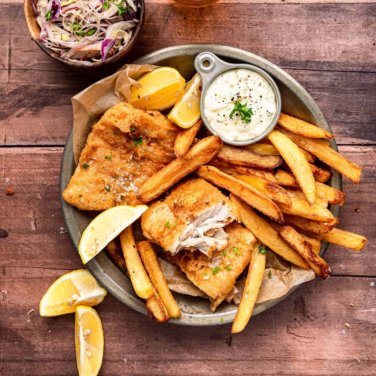 Battered fish and golden chips with lemon wedges and tartare sauce